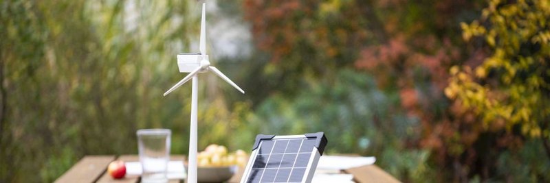 Windenergie Modell und Solar Modul auf Tisch im Garten